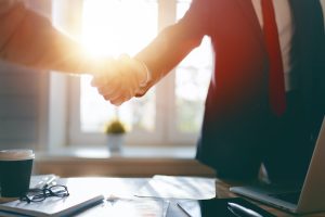 Man and woman are shaking hands in office. Collaborative teamwork.