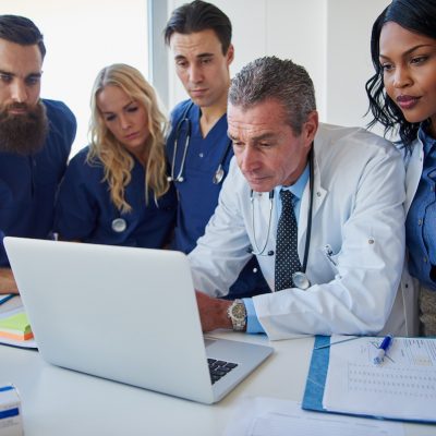 Clinical staff at a meeting. Looking at a computer together